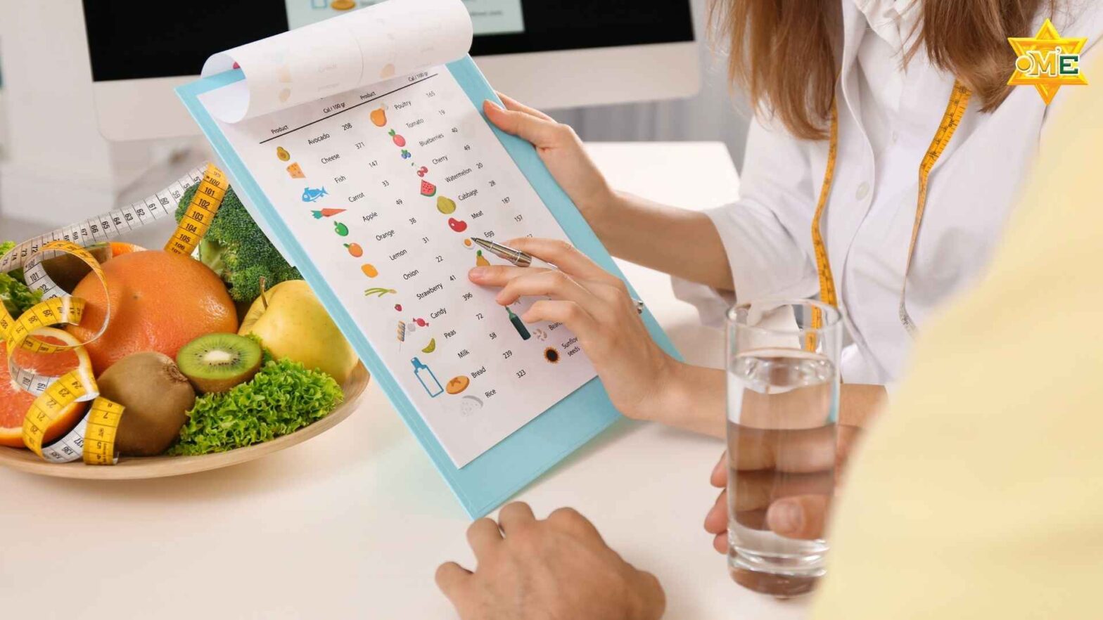 Bác sĩ dinh dưỡng tư vấn thực đơn cho bệnh nhân ung thư dạ dày, bàn có rau xanh, cá, trái cây.